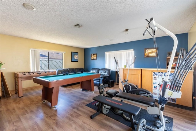 game room with a healthy amount of sunlight, pool table, a textured ceiling, and hardwood / wood-style floors