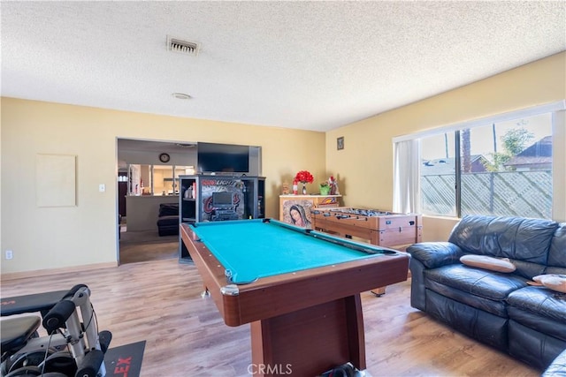 rec room with light wood-type flooring, pool table, and a textured ceiling