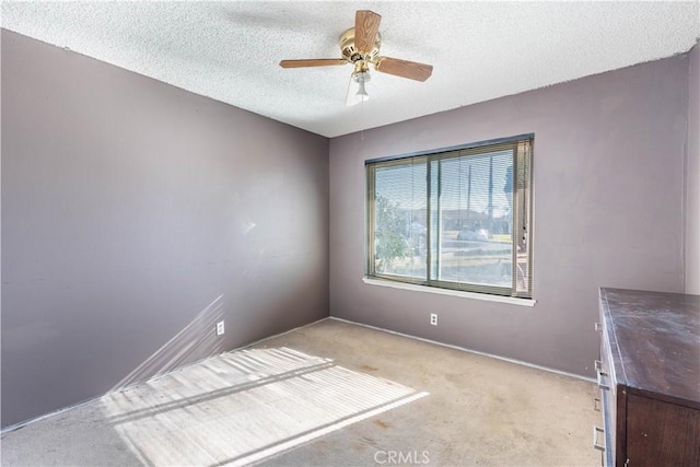 carpeted empty room featuring a textured ceiling and ceiling fan