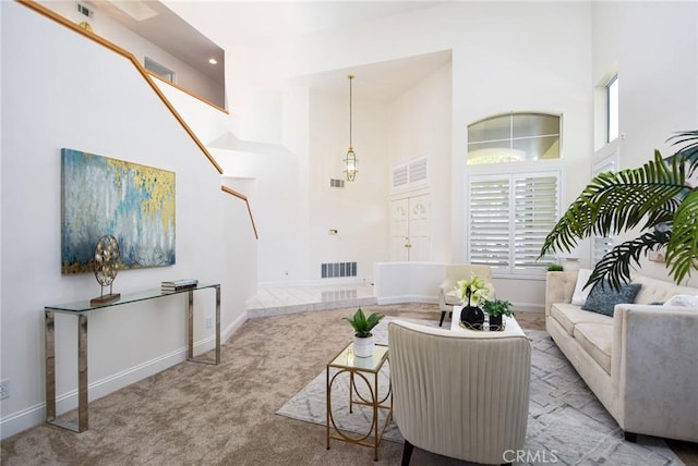 carpeted living room with a towering ceiling