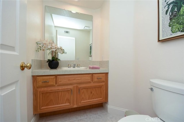 bathroom featuring tile patterned flooring, vanity, and toilet