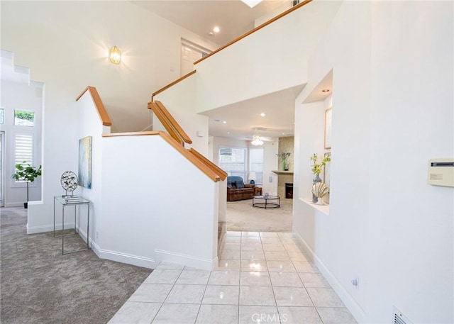 corridor featuring a high ceiling and light colored carpet