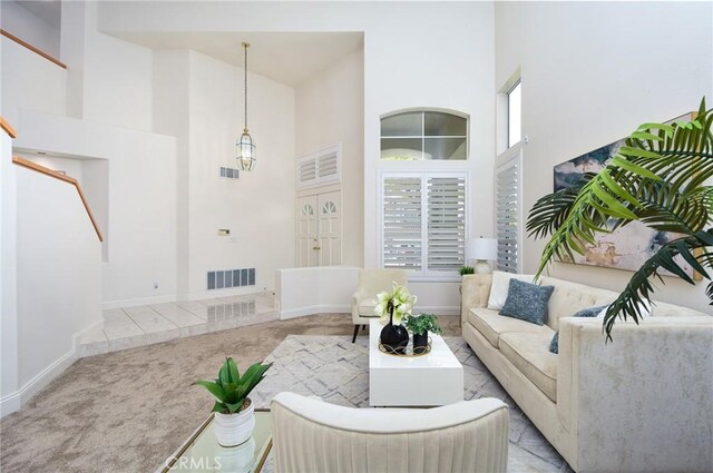 carpeted living room with a towering ceiling