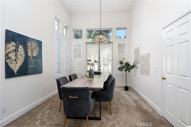 carpeted dining space featuring a chandelier