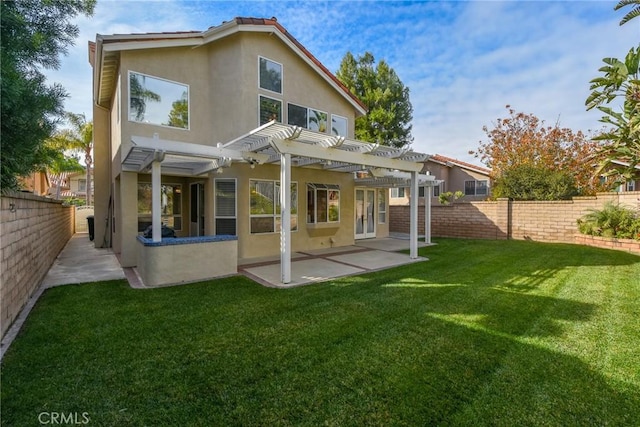 rear view of house with a pergola, a lawn, and a patio