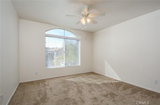 spare room with ceiling fan and light colored carpet