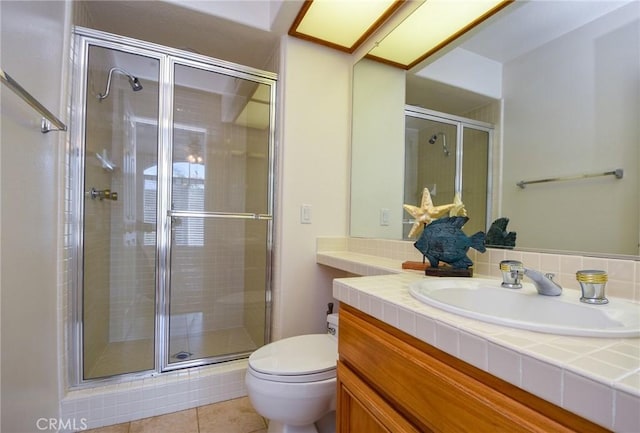 bathroom with tile patterned floors, vanity, toilet, and a shower with shower door