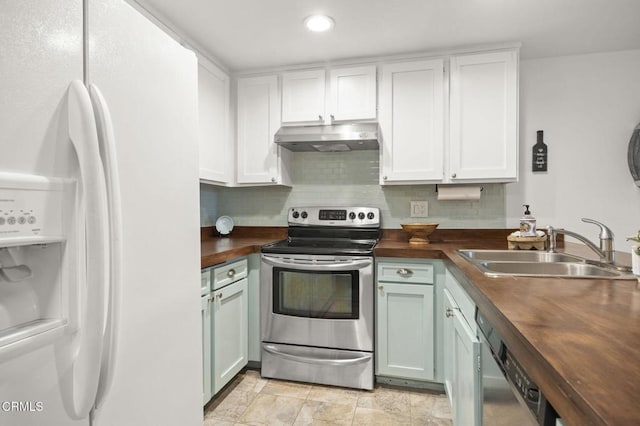 kitchen with white cabinets, appliances with stainless steel finishes, butcher block countertops, and sink