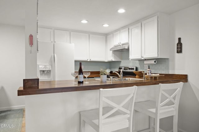 kitchen with white cabinetry, white fridge with ice dispenser, sink, backsplash, and light hardwood / wood-style floors