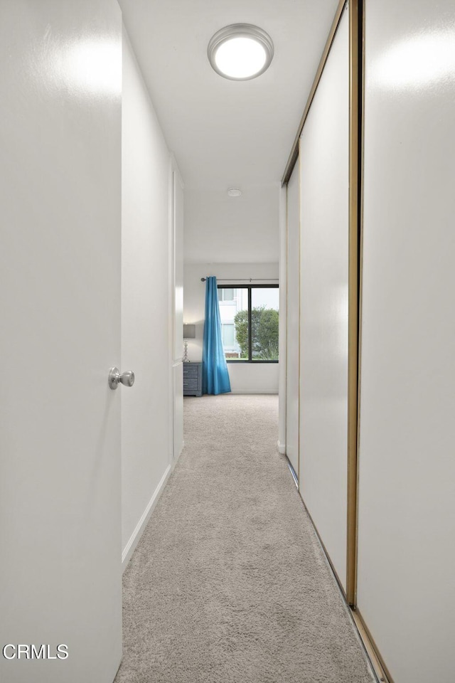 hallway featuring light colored carpet