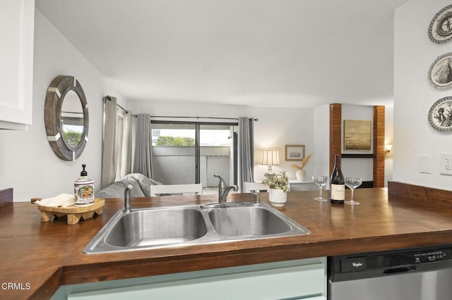 kitchen with butcher block countertops, stainless steel dishwasher, and sink