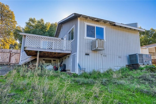 rear view of property featuring a wooden deck and cooling unit