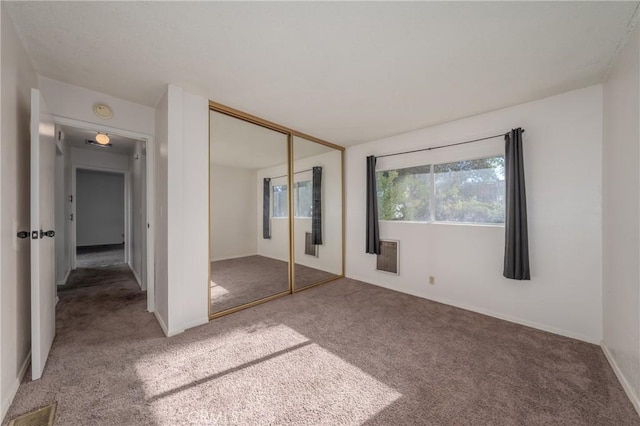 unfurnished bedroom featuring carpet flooring and a closet