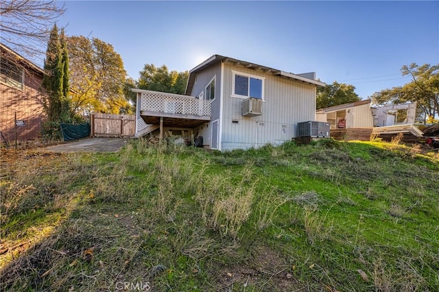 rear view of house with central AC unit and a wooden deck