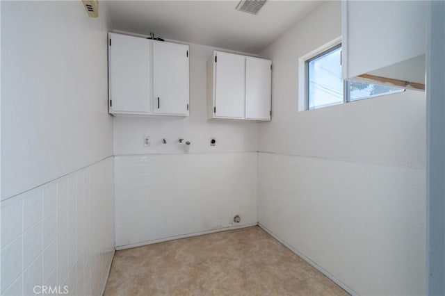 laundry area featuring cabinets, washer hookup, tile walls, and hookup for an electric dryer