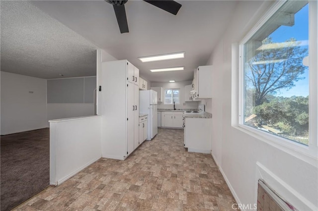 kitchen featuring white cabinets, white appliances, plenty of natural light, and ceiling fan