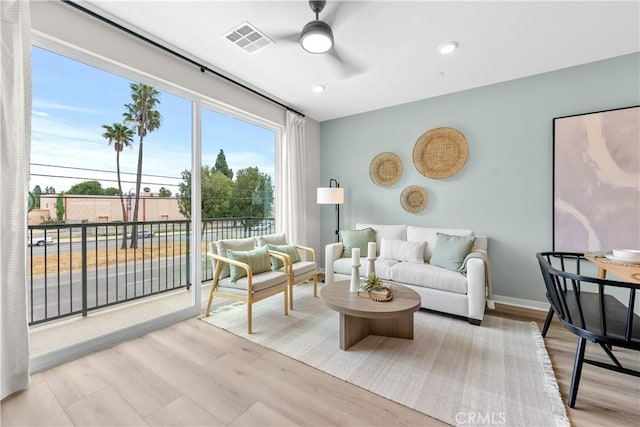 living room featuring light wood-type flooring and ceiling fan