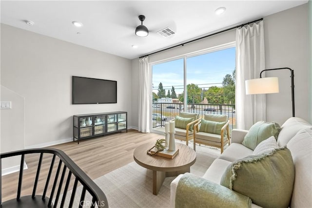 living room with light hardwood / wood-style flooring and ceiling fan