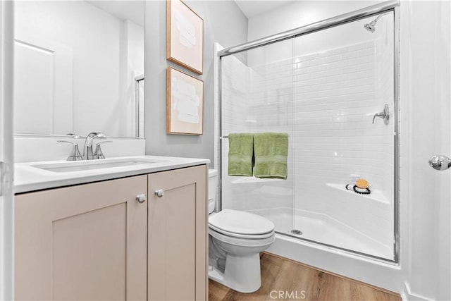 bathroom featuring vanity, hardwood / wood-style flooring, toilet, and an enclosed shower