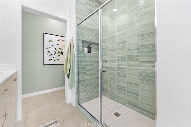 bathroom featuring tile patterned flooring, vanity, and walk in shower