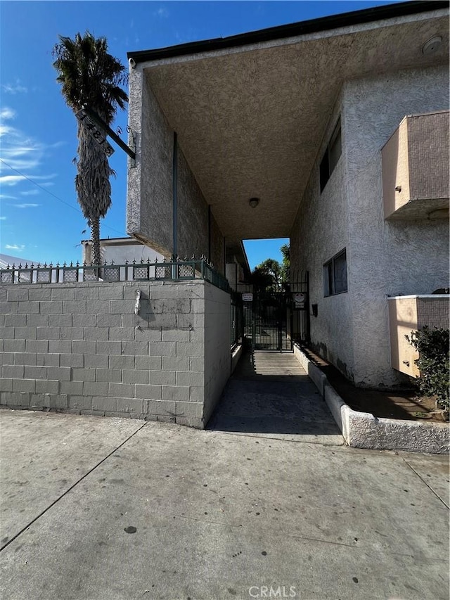 14815 Crenshaw Blvd, Gardena, CA 90249 - view of side of home featuring a gate and stucco siding