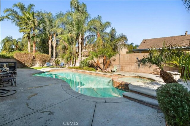 view of pool featuring a patio area and an in ground hot tub