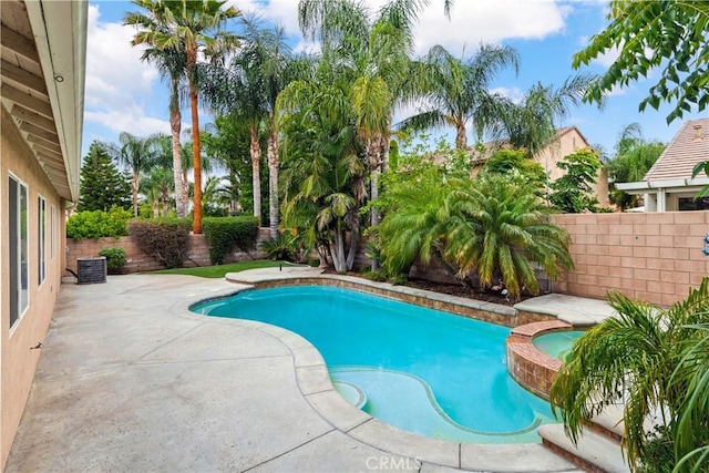 view of swimming pool with an in ground hot tub, cooling unit, and a patio area