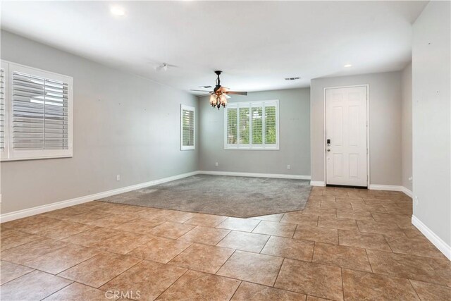 unfurnished room with light colored carpet and ceiling fan