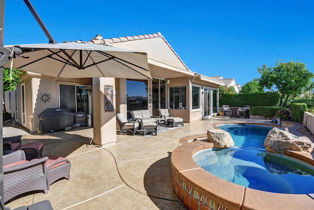 view of swimming pool featuring a jacuzzi, a patio, and area for grilling