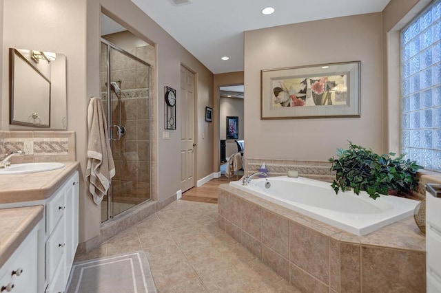 bathroom featuring tile patterned floors, vanity, and shower with separate bathtub