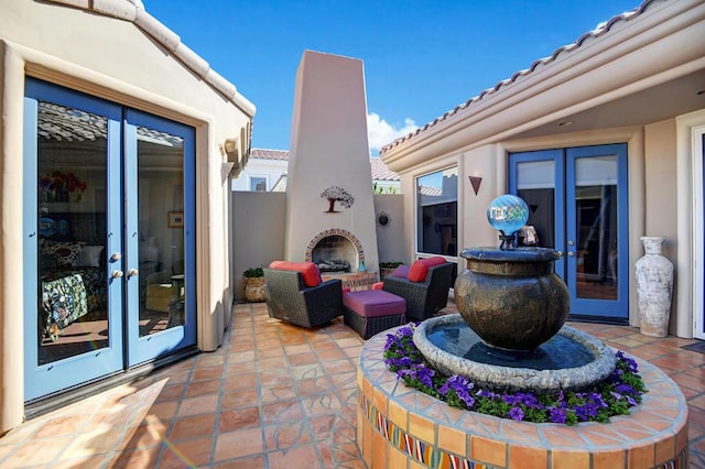 view of patio featuring french doors and an outdoor fireplace