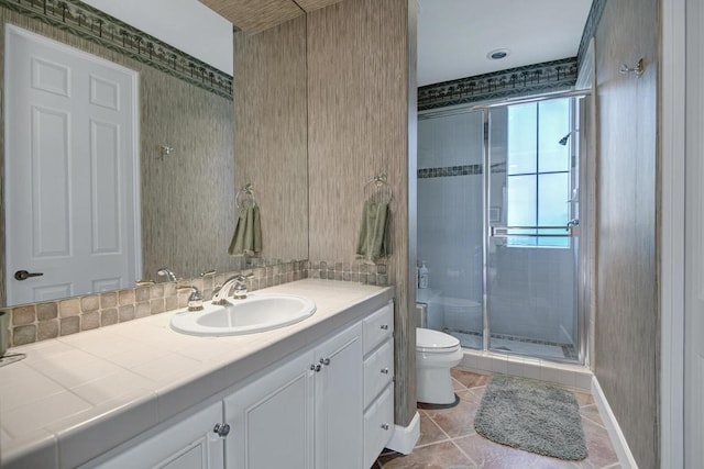 bathroom with an enclosed shower, vanity, toilet, and tile patterned floors