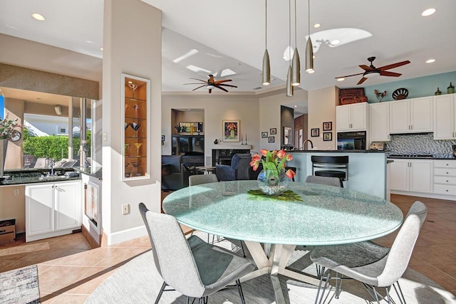 dining space with ceiling fan, crown molding, and light tile patterned flooring