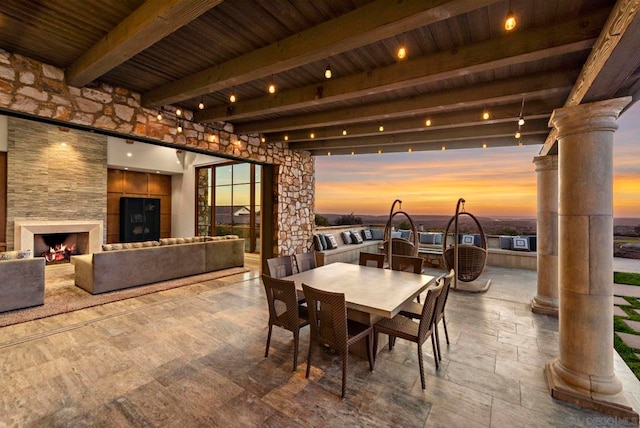 dining space with beamed ceiling, exterior fireplace, and wooden ceiling