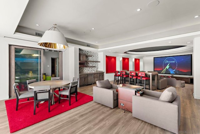 living room with hardwood / wood-style floors and a raised ceiling