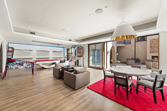 interior space with a raised ceiling, a fireplace, and hardwood / wood-style flooring