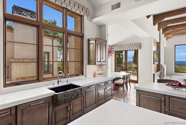 kitchen featuring high vaulted ceiling, sink, hardwood / wood-style flooring, beamed ceiling, and dark brown cabinetry