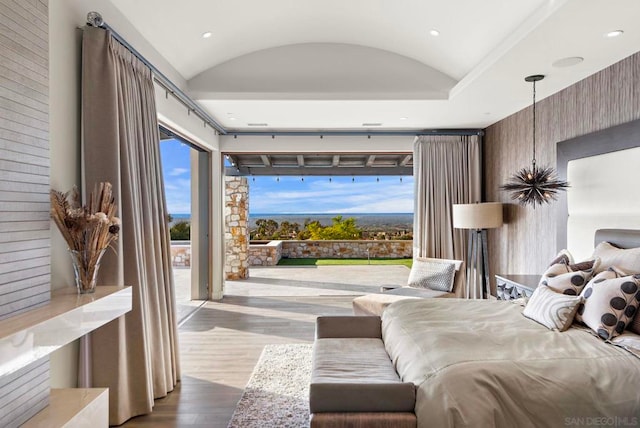 bedroom with access to exterior, wood-type flooring, and lofted ceiling