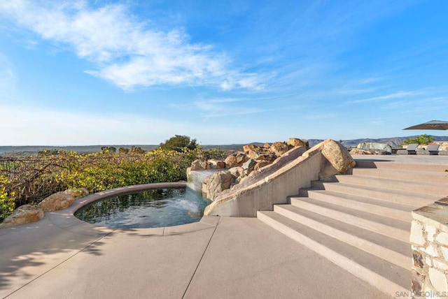 view of swimming pool with pool water feature