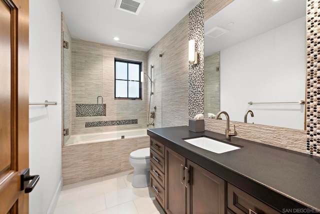 full bathroom featuring tile patterned floors, vanity, toilet, and tiled shower / bath