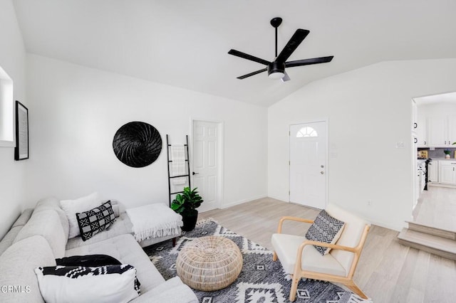 living room featuring ceiling fan, vaulted ceiling, and light hardwood / wood-style flooring