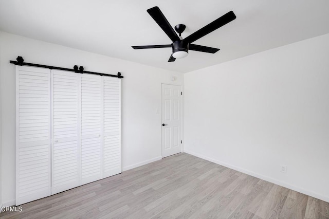 unfurnished bedroom featuring a closet, ceiling fan, and light hardwood / wood-style flooring