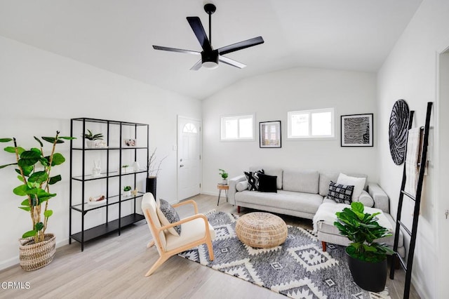 living room with light hardwood / wood-style floors, vaulted ceiling, and ceiling fan