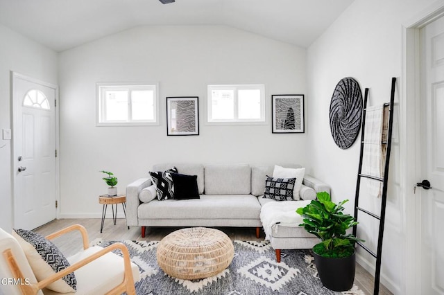 living room featuring light wood-type flooring, a wealth of natural light, and lofted ceiling