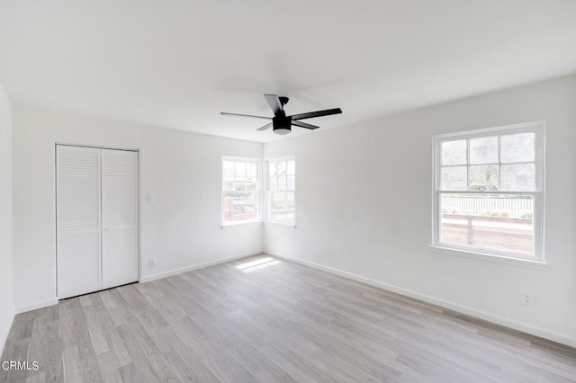 unfurnished bedroom with a closet, light hardwood / wood-style flooring, and ceiling fan