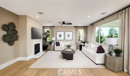 living room with light hardwood / wood-style floors and ceiling fan