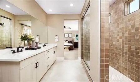 bathroom featuring a tile shower and vanity