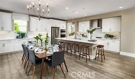 dining space featuring hardwood / wood-style floors, sink, and an inviting chandelier