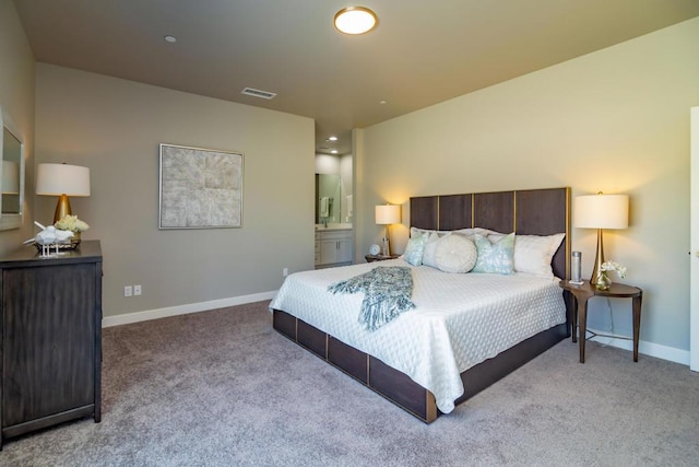 bedroom with light carpet and ensuite bathroom