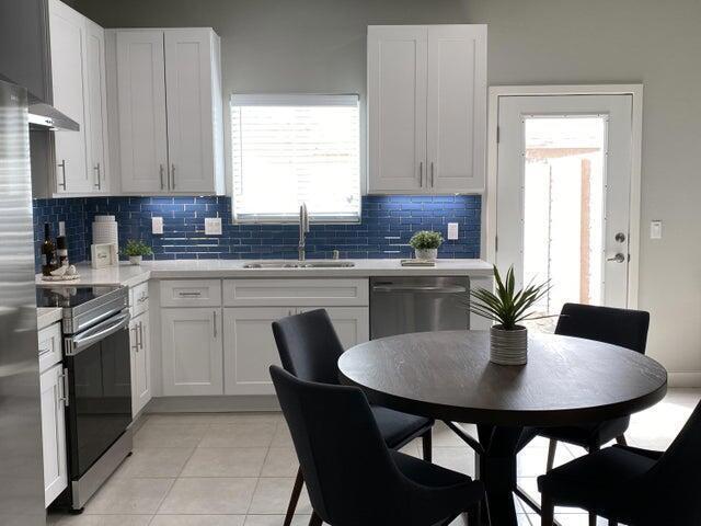 kitchen featuring a wealth of natural light, sink, white cabinets, and stainless steel appliances